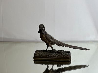 statue of a pheasant on a glass table with a white background