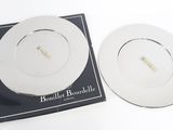 deux assiettes blanches posées sur une assiette noire et blanche
