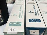 three boxes of toothpaste sitting on top of a bed next to a bottle of toothpaste