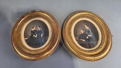Deux portraits encadrés représentant des femmes en robe bleue sont posés sur une table.