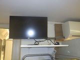 une télévision à écran plat fixée au mur au-dessus d'une cuisinière