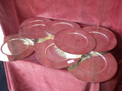 cinq assiettes rouges posées sur une nappe rouge, ornée d'un ruban doré