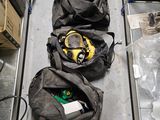 three bags of gas masks on a conveyor belt