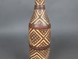 un vase marron orné d'un motif, posé sur une table