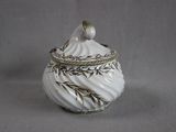 a white vase with a bird sitting on top of it