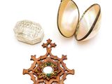 deux bijoux, dont un œuf, une croix et une pièce de monnaie