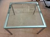 a glass table with a glass top on a carpeted floor