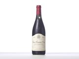 a bottle of red wine sitting on top of a white table