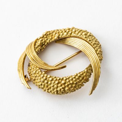 une image représentant une broche en or ornée d'un motif en spirale
