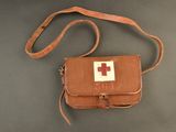 leather first aid bag with red cross on it on a table