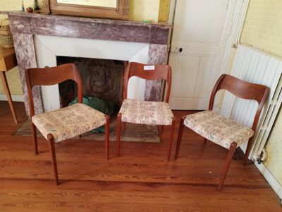 trois fauteuils placés devant une cheminée dans un salon
