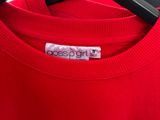 a person holding a red t - shirt with a heart on it