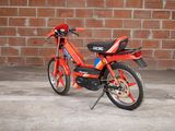 a red motorcycle parked in front of a brick wall