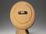 a ring sitting on top of a sculpture on a stand