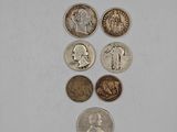 several different coins are arranged in a row on a white surface