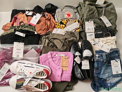 un tas de vêtements et de chaussures posés sur une table blanche