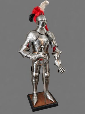 a statue of a knight in full armor with a red feather on his head