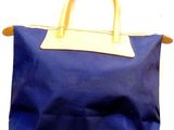 a blue bag with a tan handle hanging on a wall