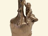 a bronze statue of a woman and a child in a vase
