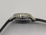 a close up of a watch on a white surface with a black strap