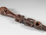 une image représentant une pipe en bois sur laquelle est sculpté un visage