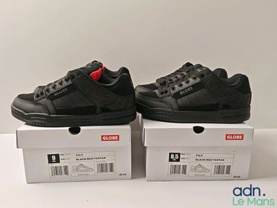 two pairs of black sneakers sitting on top of a white box