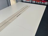 a white table with a laptop on it in a room