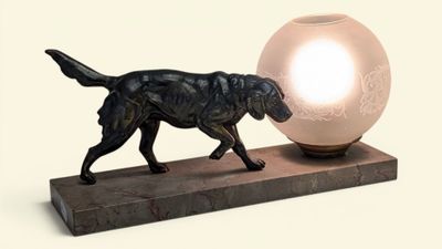statue d'un chien tenant une balle dans la gueule, posée sur un socle