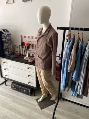 a mannequin in front of a rack of clothes