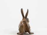 bronze sculpture of a rabbit on a white background