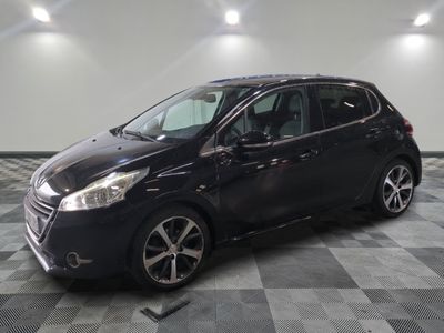 la voiture noire est garée sur un sol en damier dans le garage