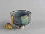 un bol bleu et vert avec une banane à côté