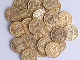 a pile of gold coins sitting on a white surface