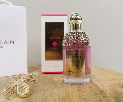 the bottle of perfume is next to the box on the table