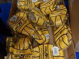 une boîte remplie de ballons de basket jaunes emballés dans du plastique