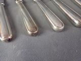 five silverware spoons and a knife on a table