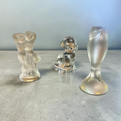 trois figurines en verre posées sur une table