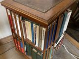 a small wooden table with a book case on top of it