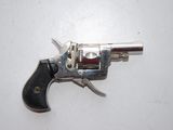 a silver revolver with a black handle on a white surface
