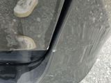 a reflection of a person standing in a car door