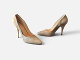 two pairs of nude colored high heels on a white surface
