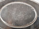 a silver plate with a silver rim on a table