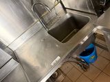 a small kitchen with stainless steel counter tops and a blue bucket