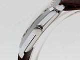 a close up of a watch on a wooden stand on a white surface