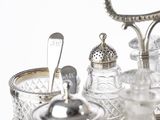 a silver tray with glass jars and spoons on it