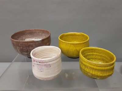 trois bols posés sur une table en verre, sur fond gris