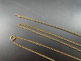 three gold chains on a black surface