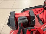 a red cordless drill and a red tool bag on the floor