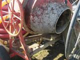 une bétonnière posée dans l'herbe à côté d'un camion