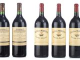 four bottles of red wine are lined up in a row